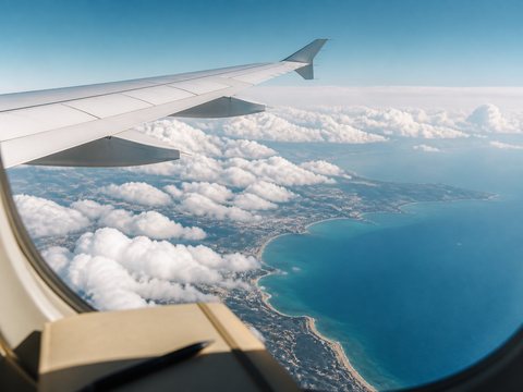 Vue d'aile d'avion au-dessus d'une c&ocirc;te m&eacute;diterran&eacute;enne